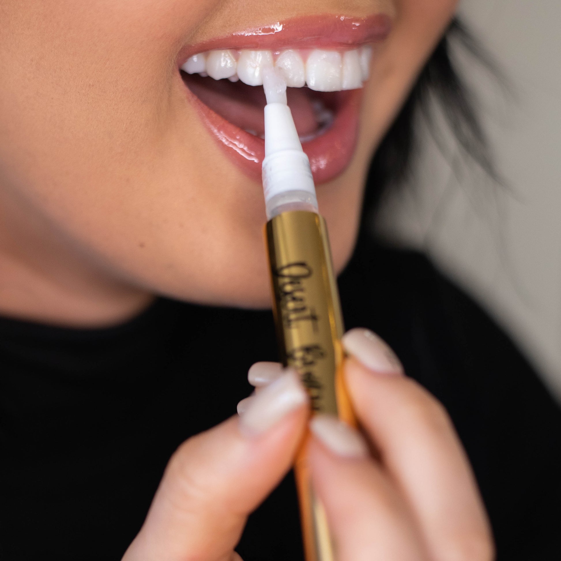 women applying teeth whitening on her teethes